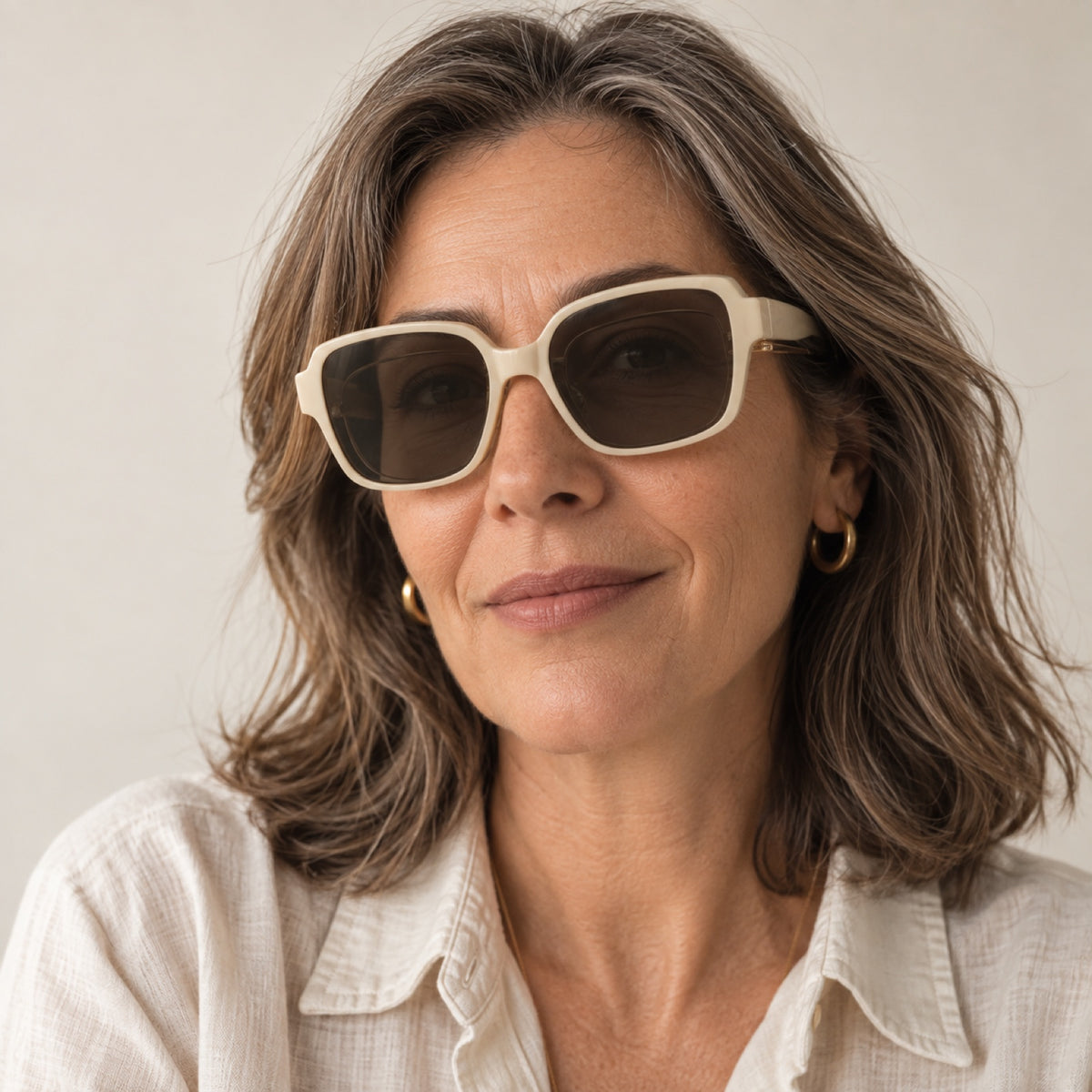 Mujer de unos 50 años usando los lentes de sol Solzia color crema