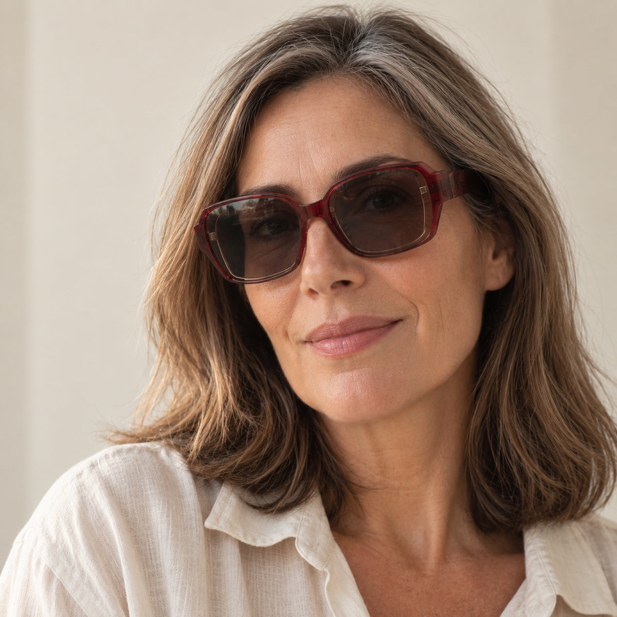 Mujer de unos 50 años usando los lentes de sol Solzia color vino